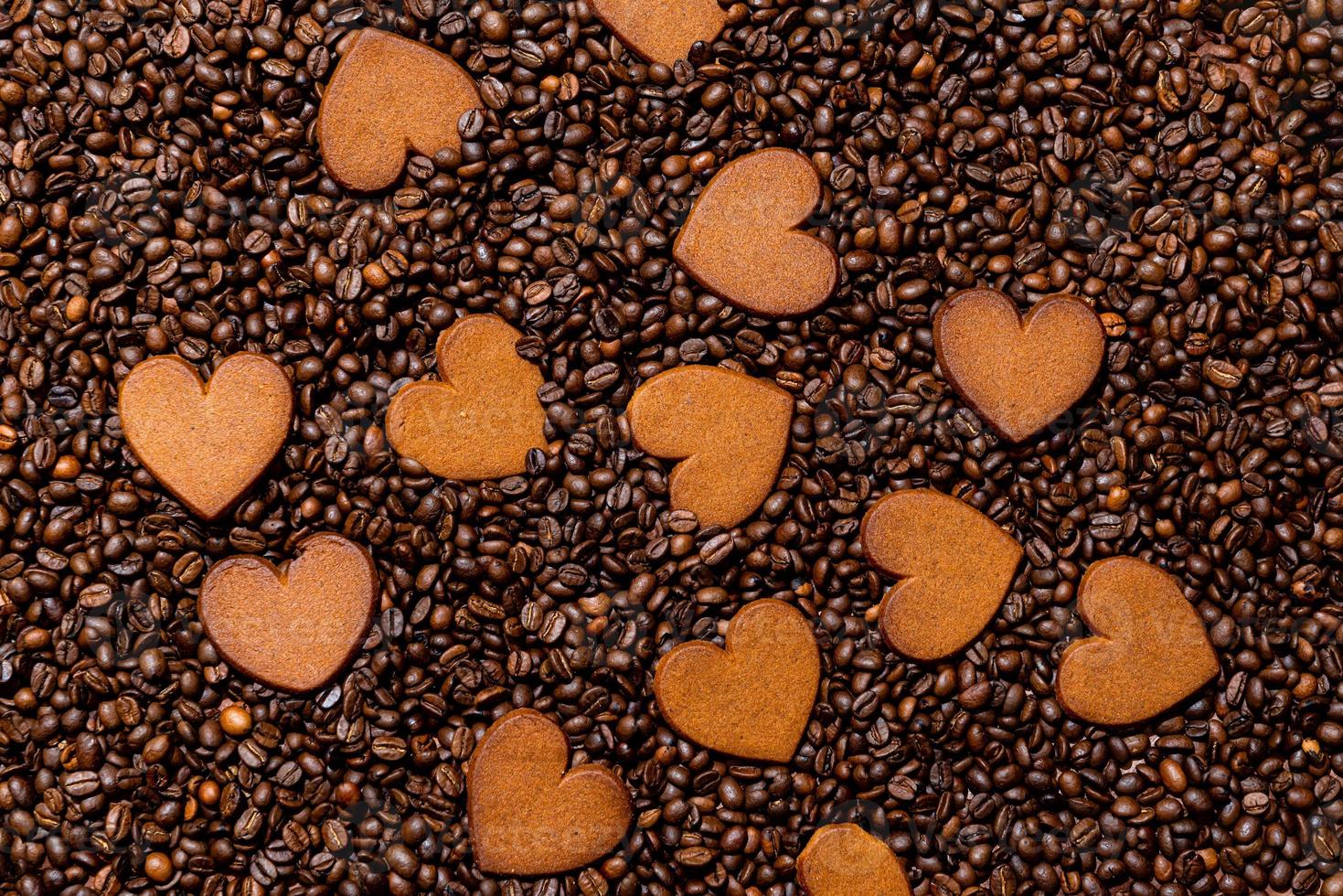 biscoitos de gengibre em forma de coração no fundo de grãos de café foto