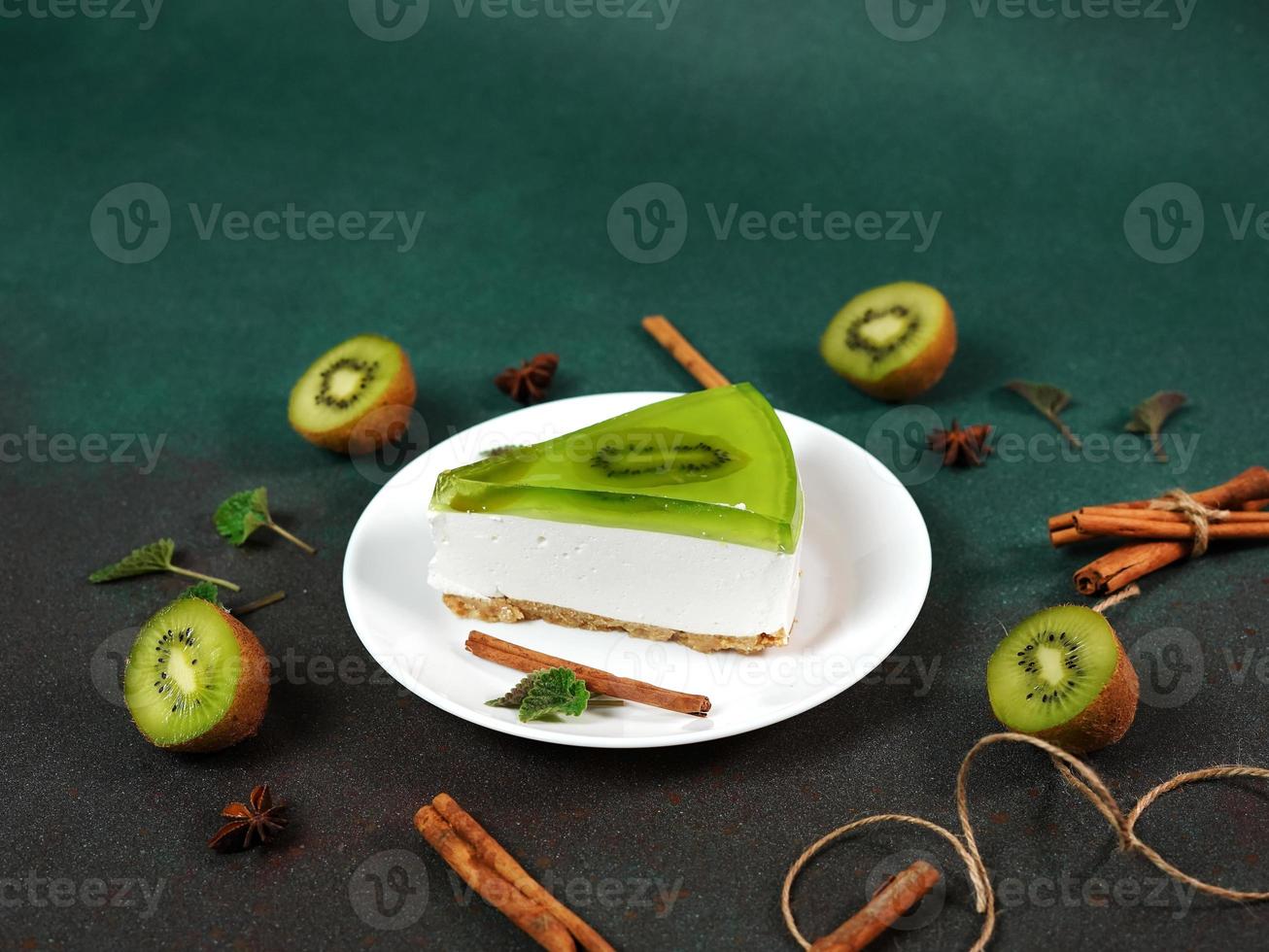 bolo de queijo com kiwi, canela bastão e folhas hortelã em uma verde fundo. cópia de cpase para texto foto