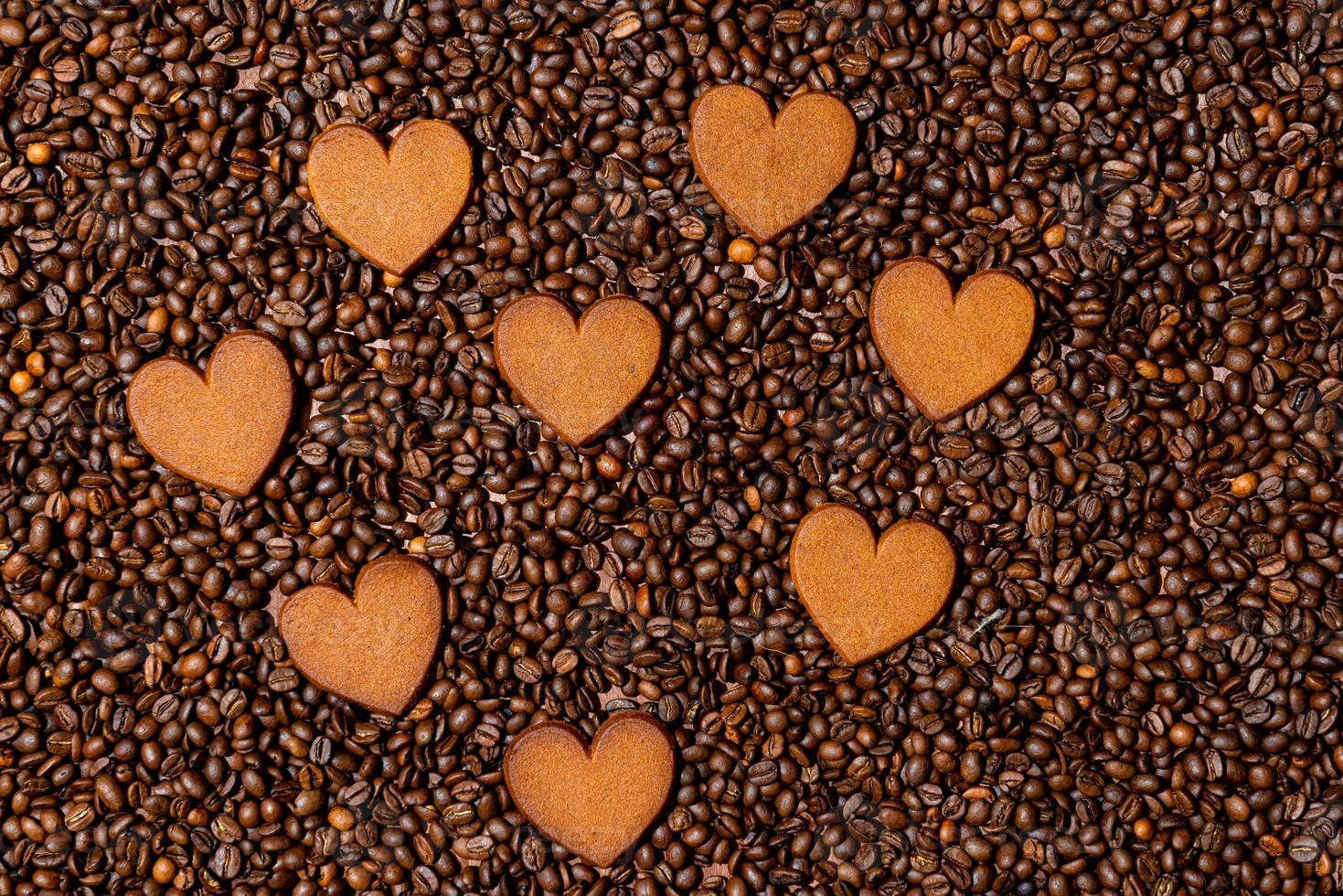 biscoitos de gengibre em forma de coração no fundo de grãos de café foto