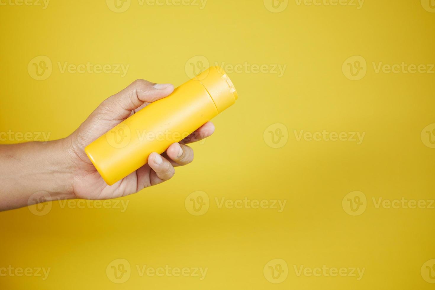 mão segurando uma protetor solar creme recipiente foto