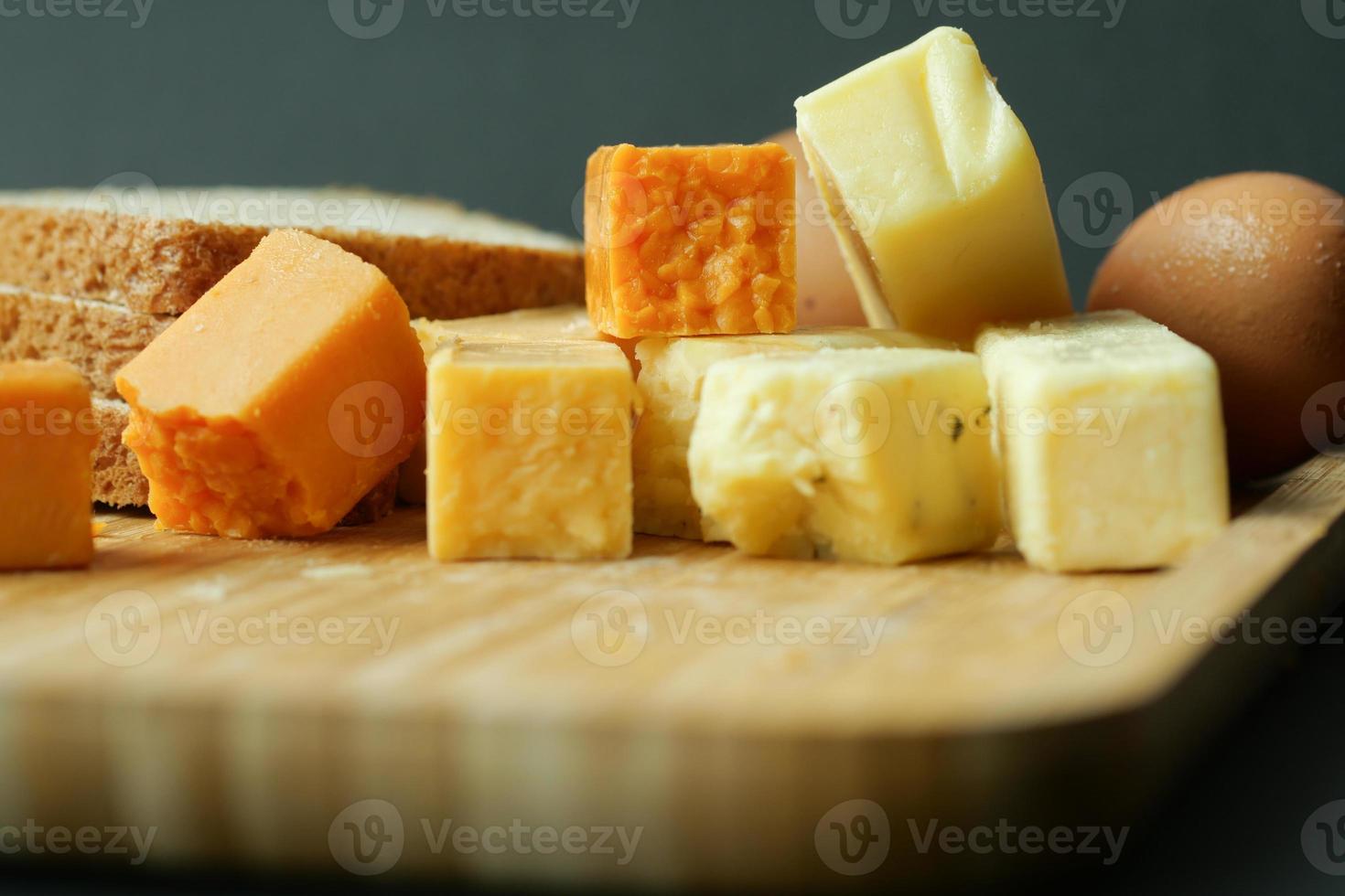 cubos de queijo cor verde, amarelo e vermelho na tábua foto