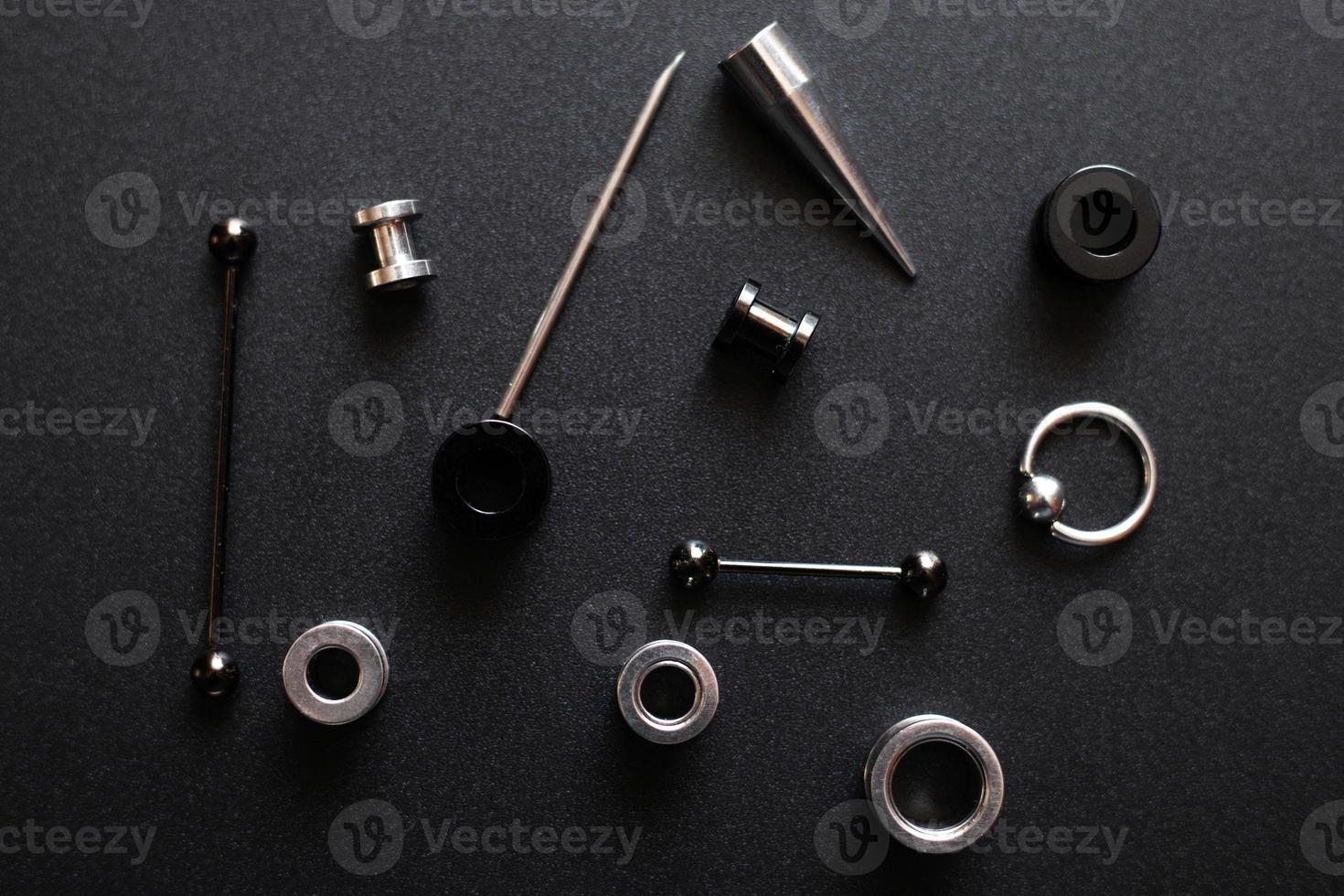 itens para um piercing de metal em fundo cinza escuro foto