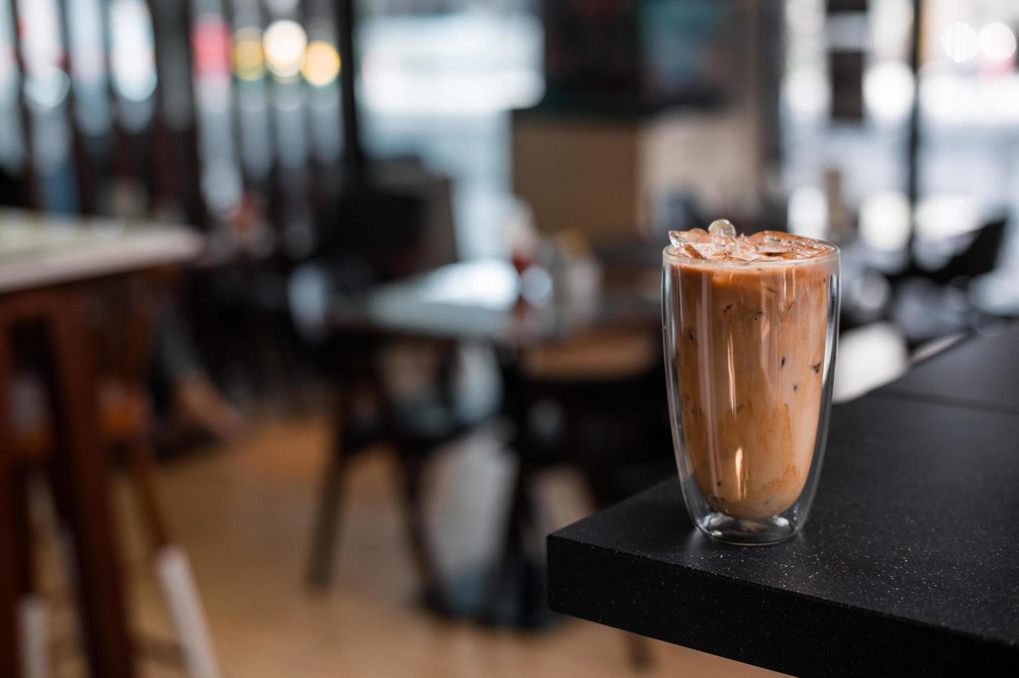 copo de café gelado com leite em cima da mesa foto