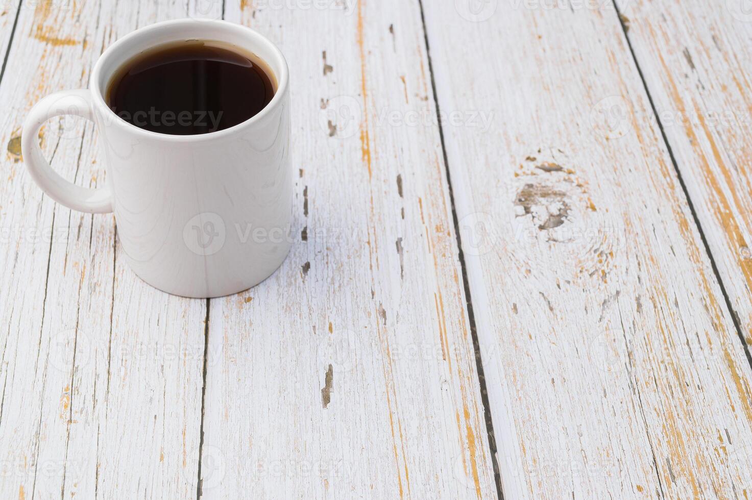 uma caneca de café em uma mesa de madeira foto