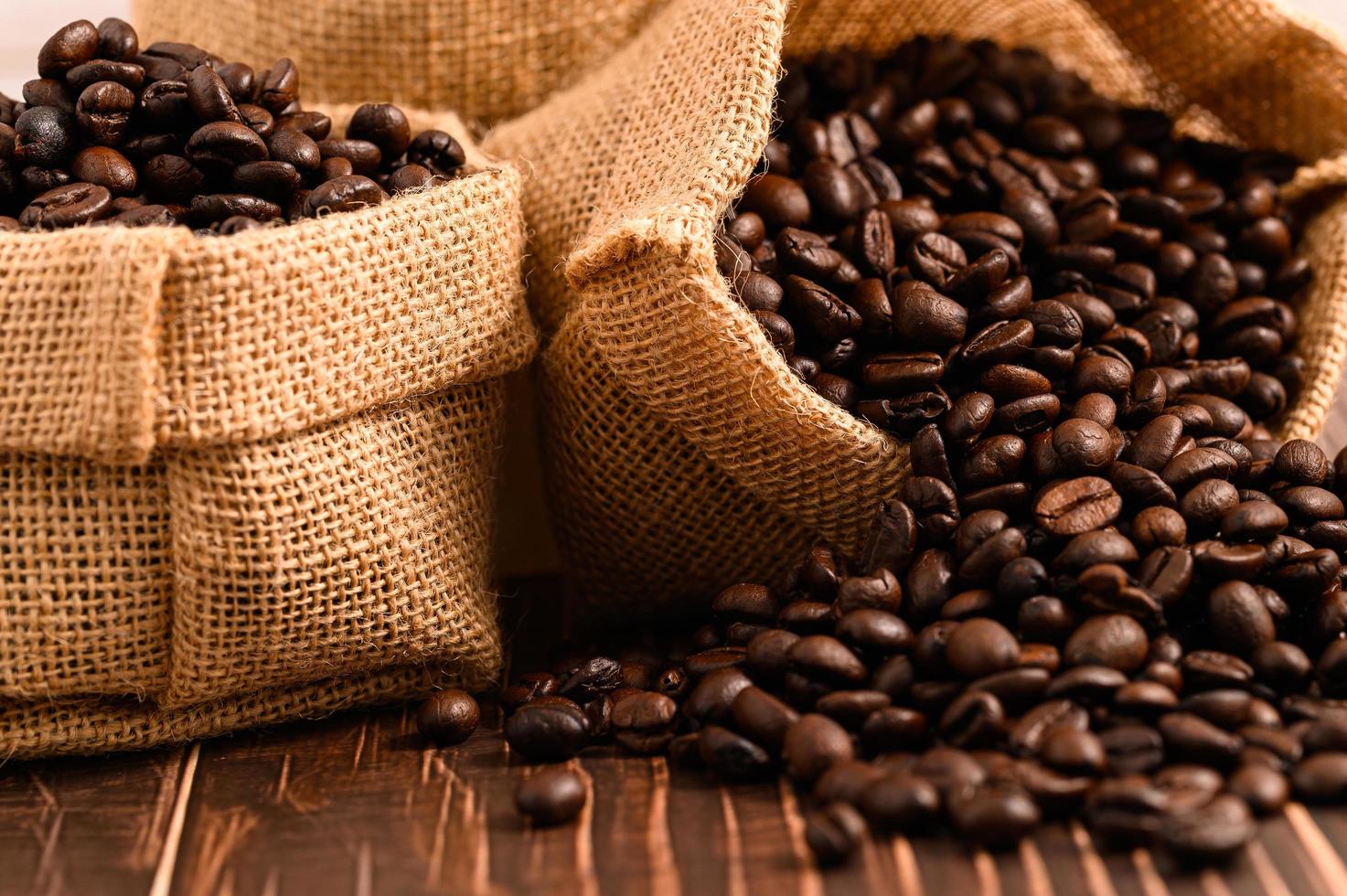 sacos de grãos de café em uma mesa de madeira foto