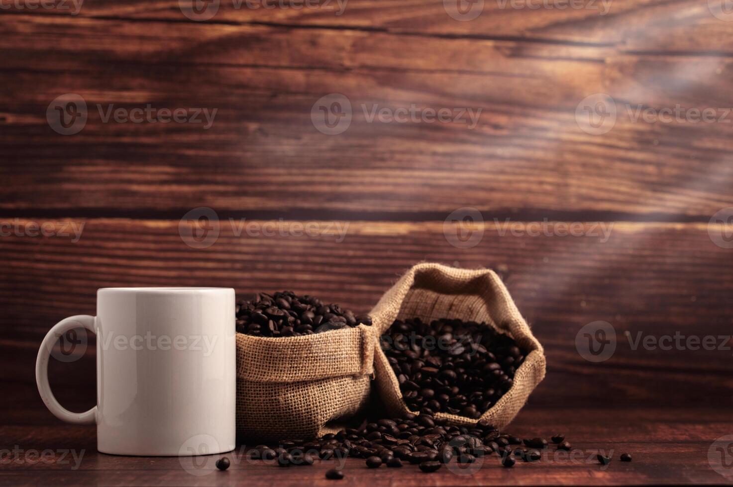 uma caneca de café e sacos de grãos de café em uma mesa de madeira foto