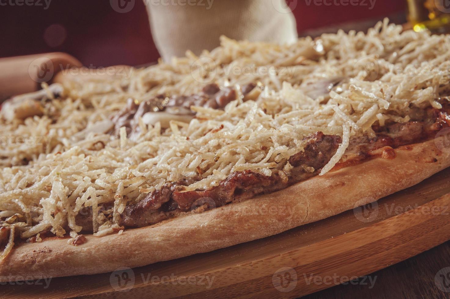 pizza com mussarela, estrogonofe de carne e palitos de batata foto