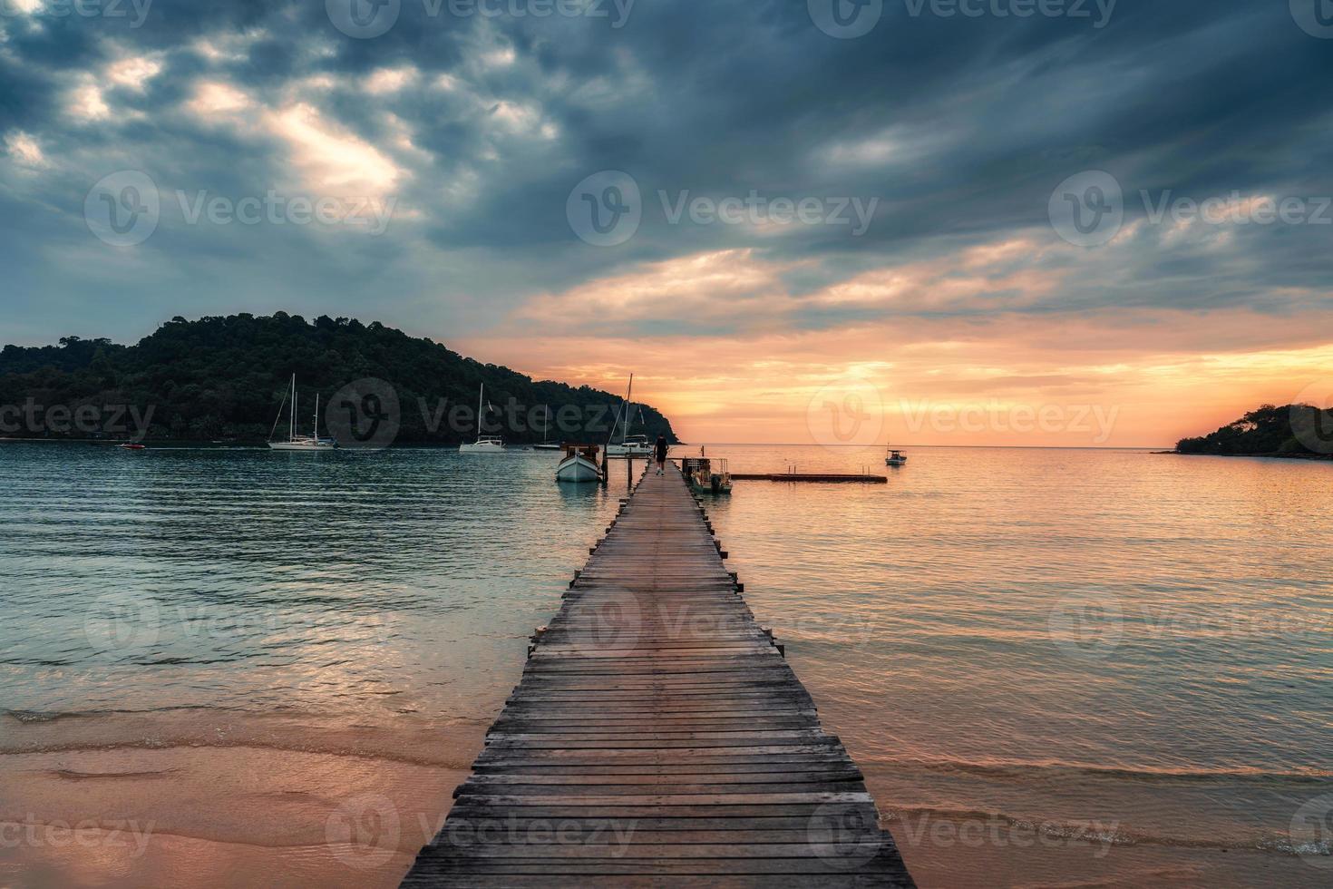 pôr do sol sobre de madeira cais e barco dentro tropical mar às koh kood ilha foto