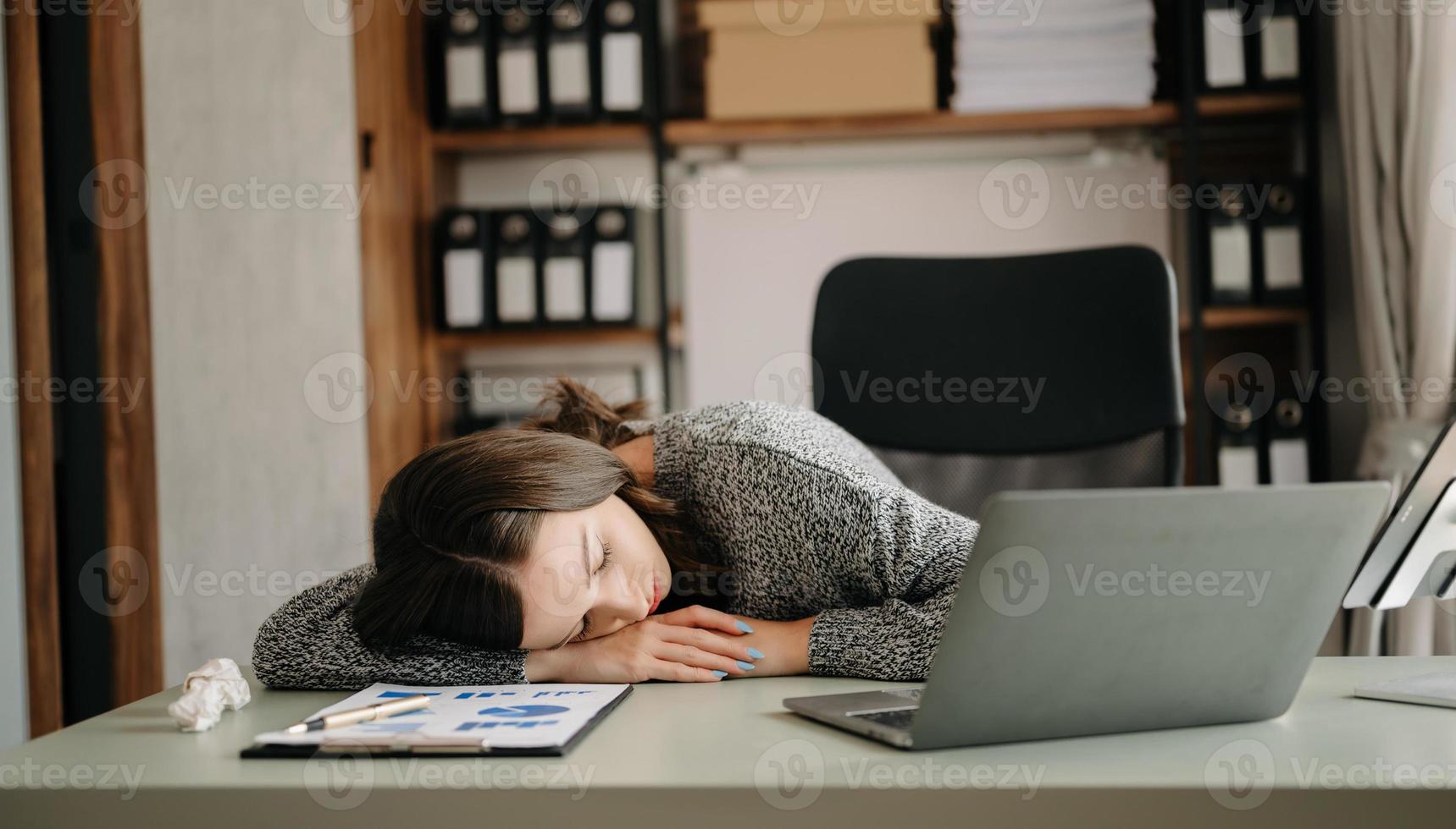 ásia o negócio mulher é estressado, entediado, e pensar demasiado a partir de trabalhando em uma tábua às a moderno escritório. foto