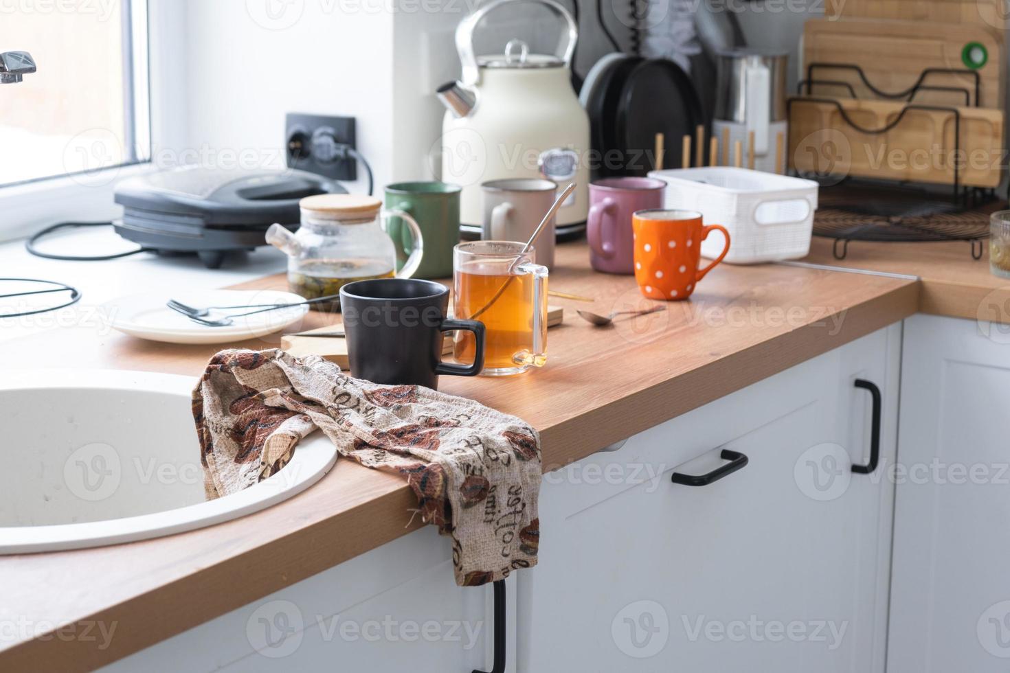 uma bagunça dentro a cozinha, sujo pratos em a mesa, espalhados coisas, anti-higiênico condições. a lava-louças é completo, a cozinha é desarrumado, todo dia vida foto