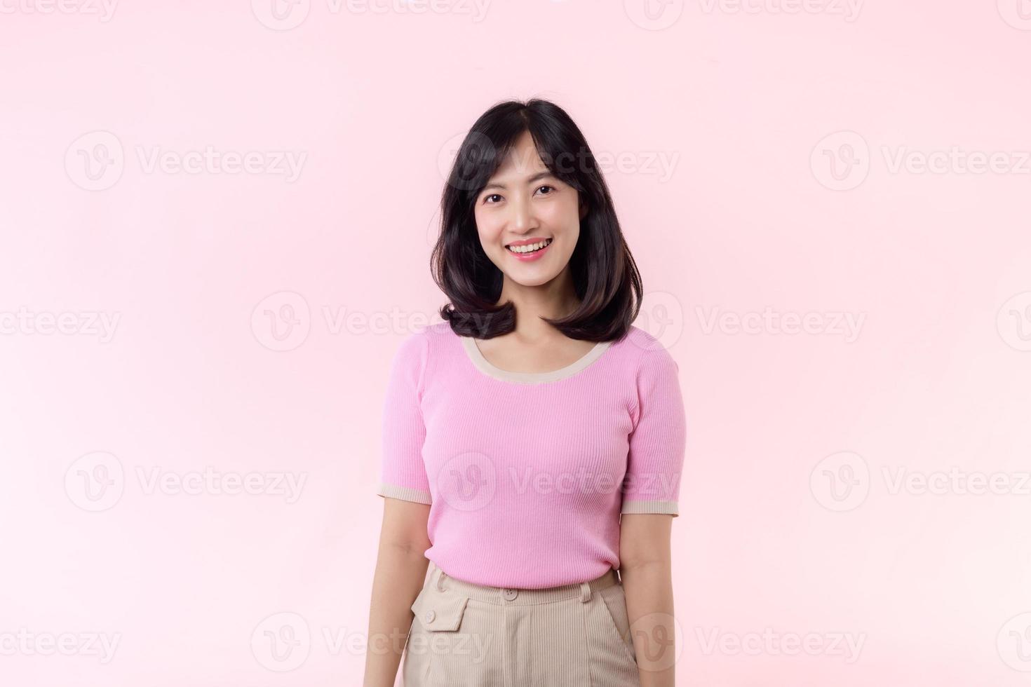 retrato lindo jovem ásia mulher modelo feliz sorrir dentro Rosa suéter casual estilo moda isolado em Rosa estúdio fundo. atraente fêmea pessoa alegre fofa face retrato, mulher dia conceito. foto