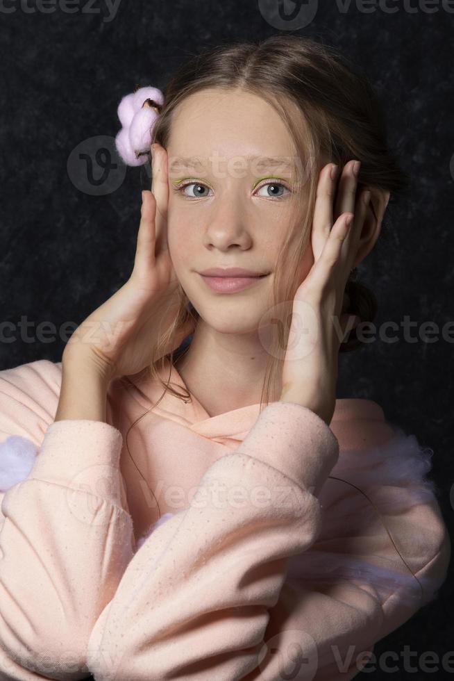 retrato do uma Adolescência menina dentro Rosa roupas em uma Sombrio fundo. foto