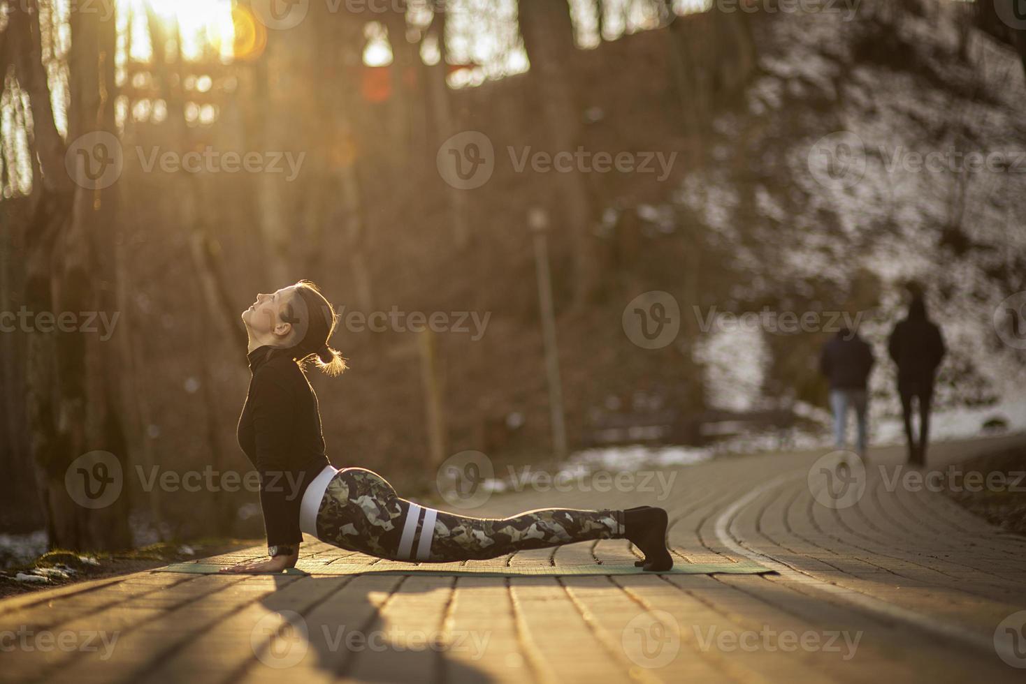 uma jovem atlética realiza exercícios de ioga e meditação ao ar livre foto