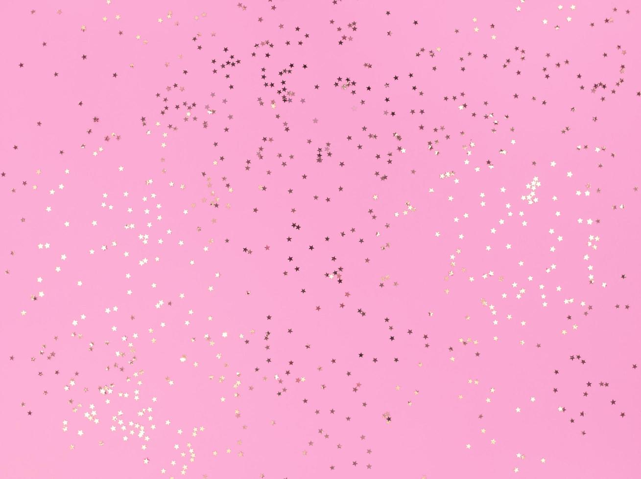 Estrelas de confete cintilando em um fundo rosa foto