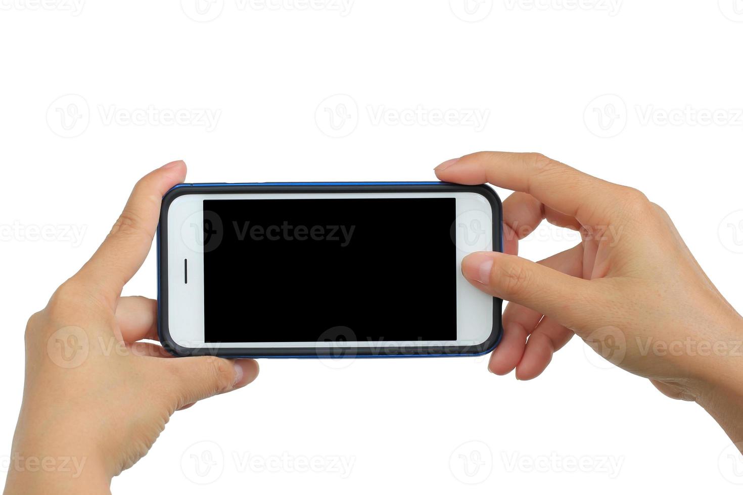 mãos segurando um smartphone móvel com uma tela em branco foto