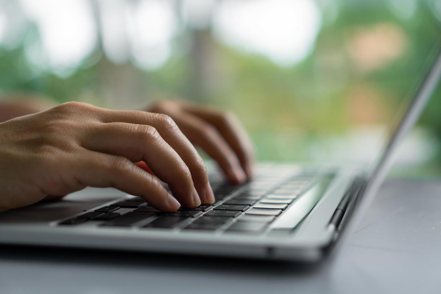 uma mão usando um laptop em busca de informações na internet foto