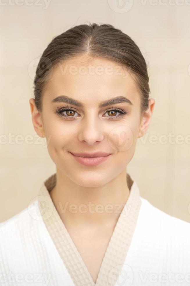 jovem mulher vestindo branco roupão de banho foto