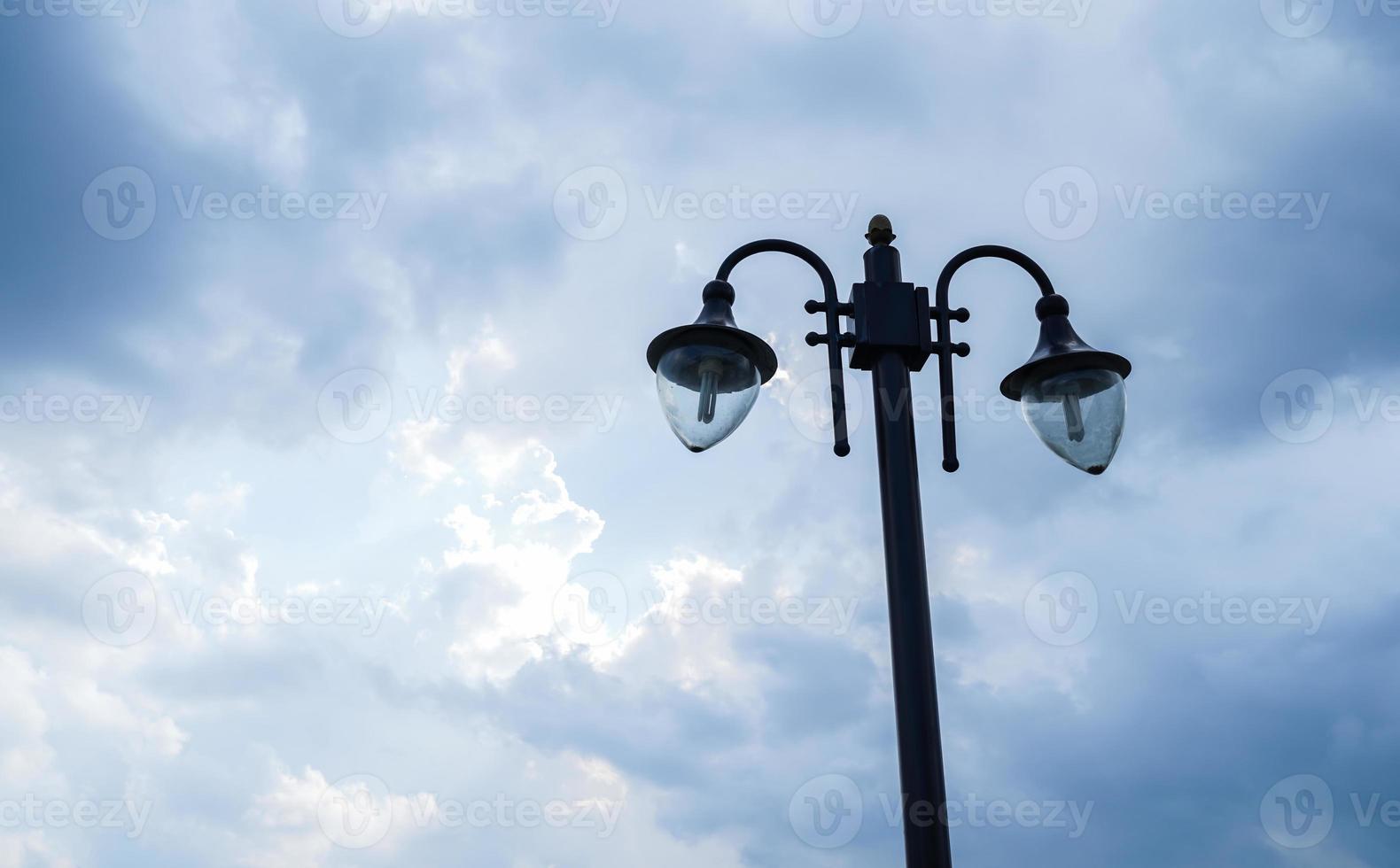 vintage rua lâmpada, com dois lâmpadas, contra uma nublado azul céu fundo foto