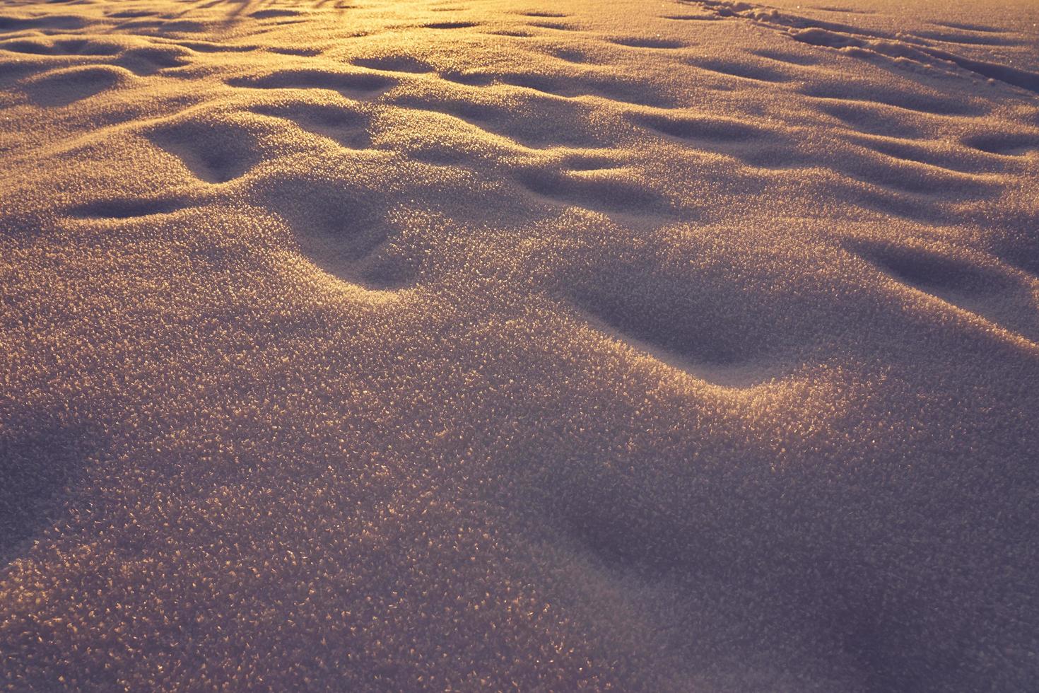 textura de neve em uma noite gelada ao pôr do sol foto