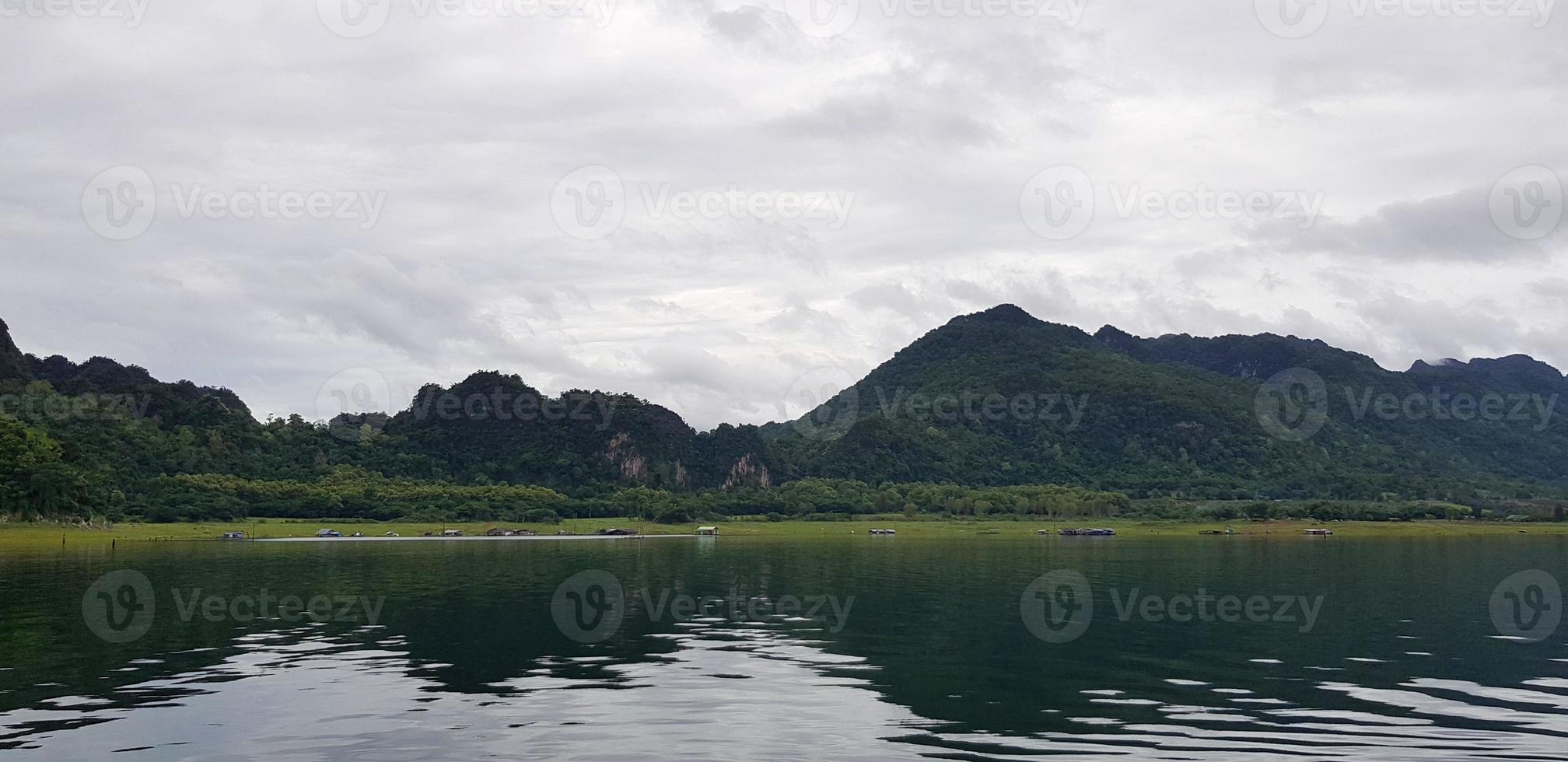 panorama do verde montanha Visão com rio ou lago, branco céu e reflexão em água às Srinakarin barragem, kanchanaburi. natural papel de parede e beleza do natureza conceito foto