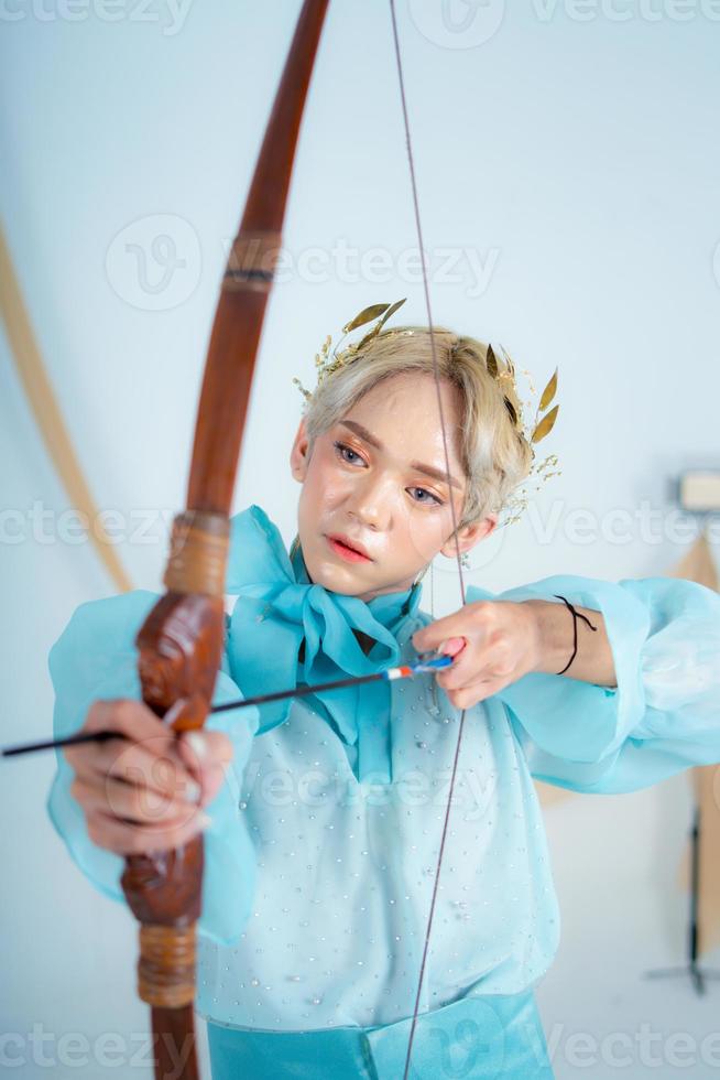 uma Princesa dentro uma azul vestir puxar uma arco com dela mão foto