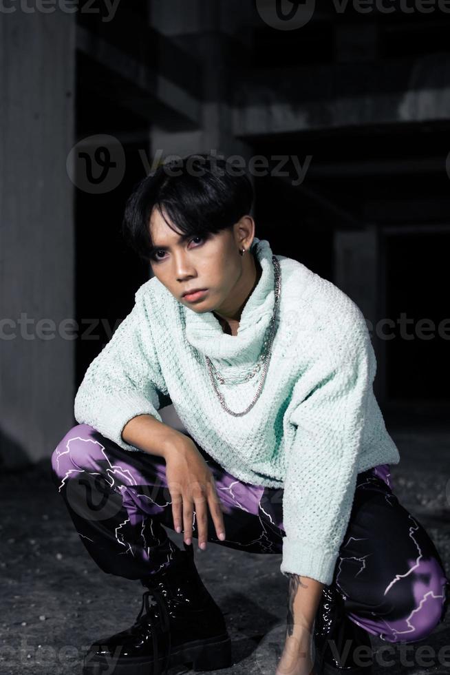 a ásia homem com Preto cabelo agachamentos muito masculino foto