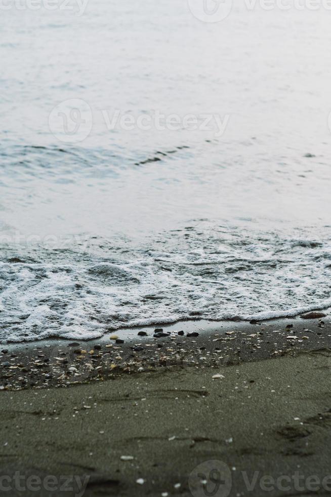 ondas às mar lavando acima em costa foto