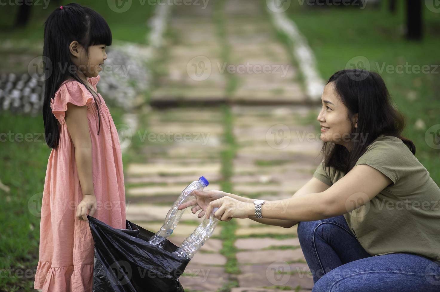 mãe e filha asiáticas ajudam o ambiente de caridade de coleta de lixo. foto