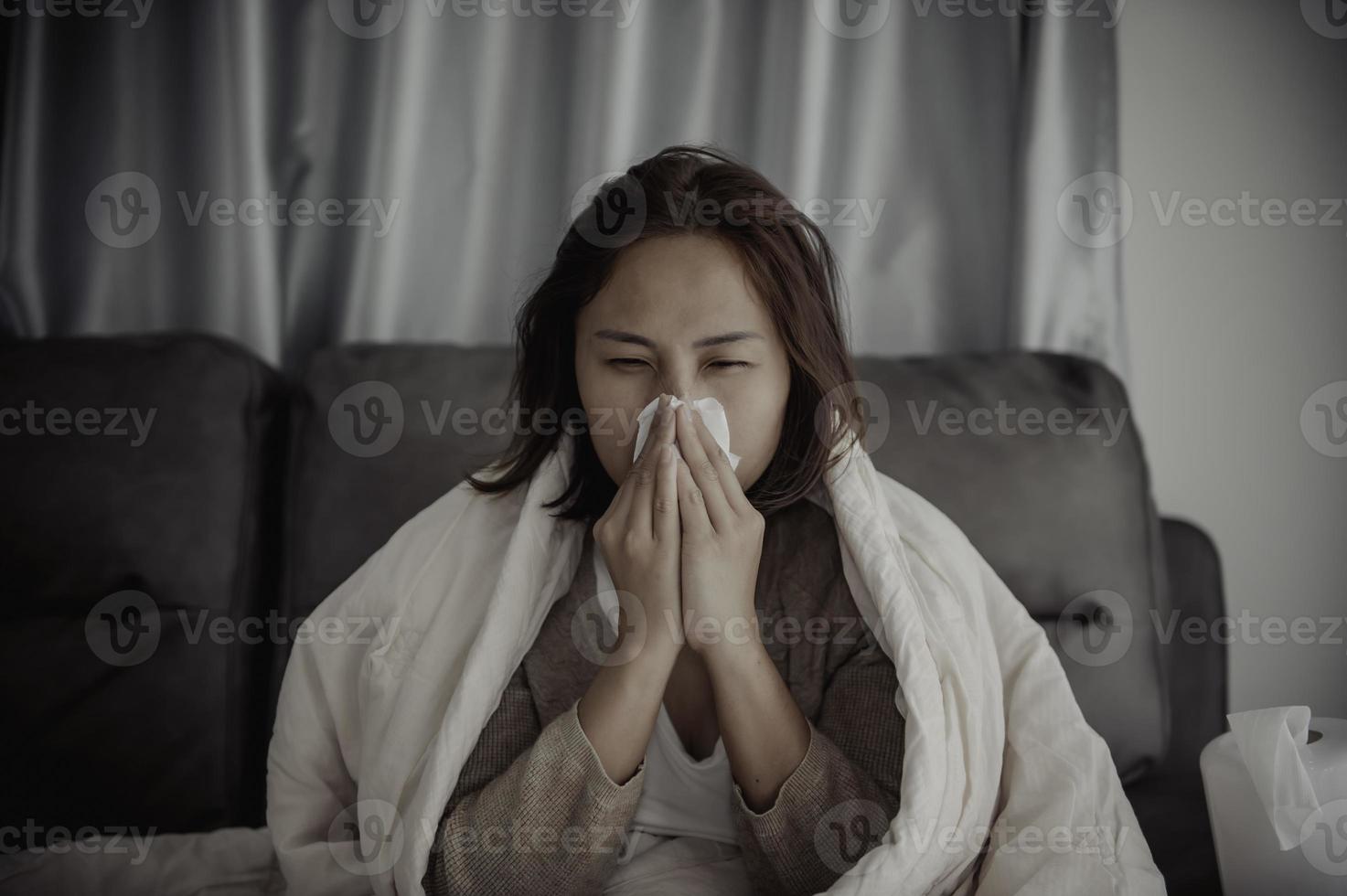 mulher asiática doente sente-se no sofá ficar em casa, a mulher se sentiu mal, queria deitar e descansar, febre alta foto