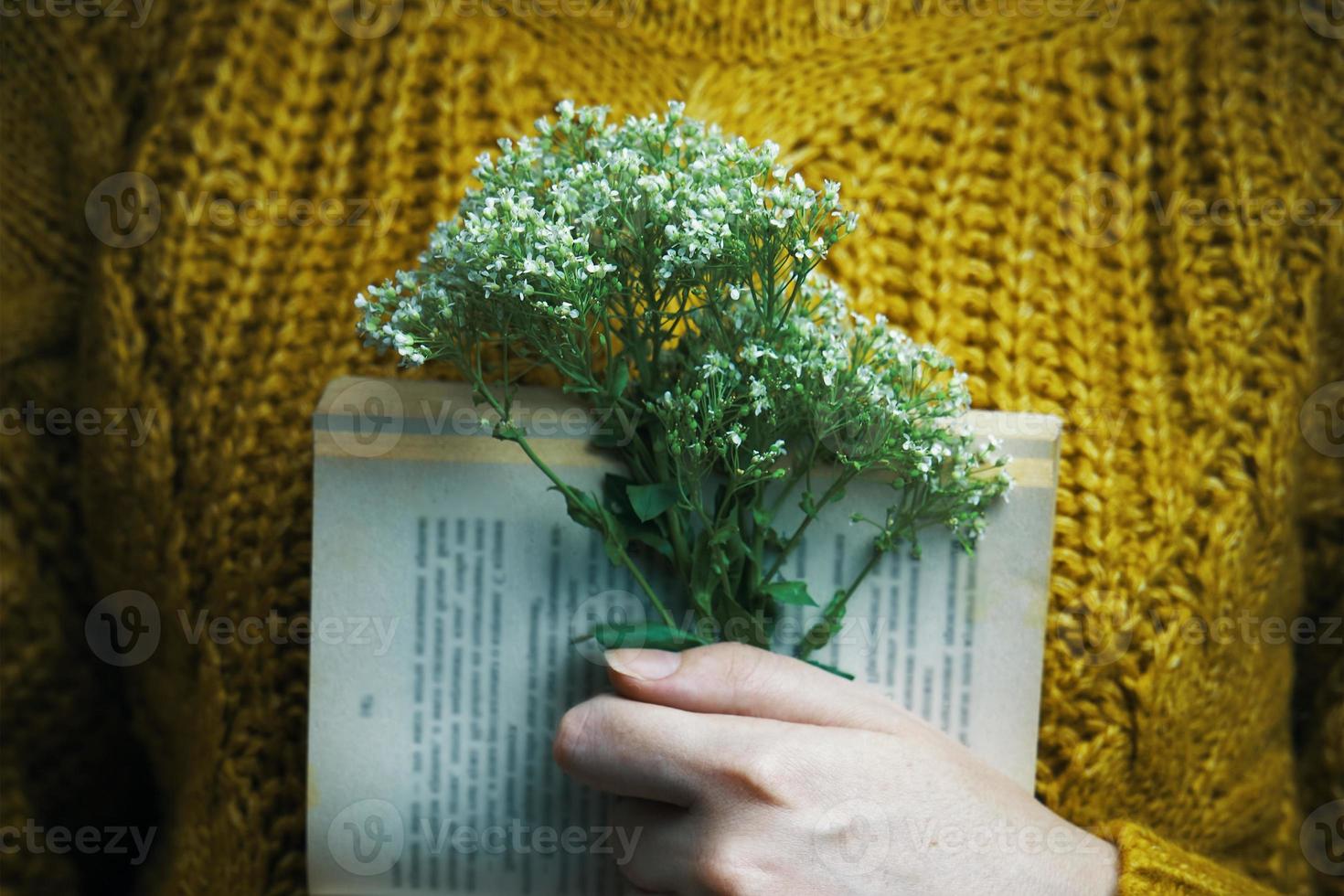 menina segurando um livro e um buquê foto