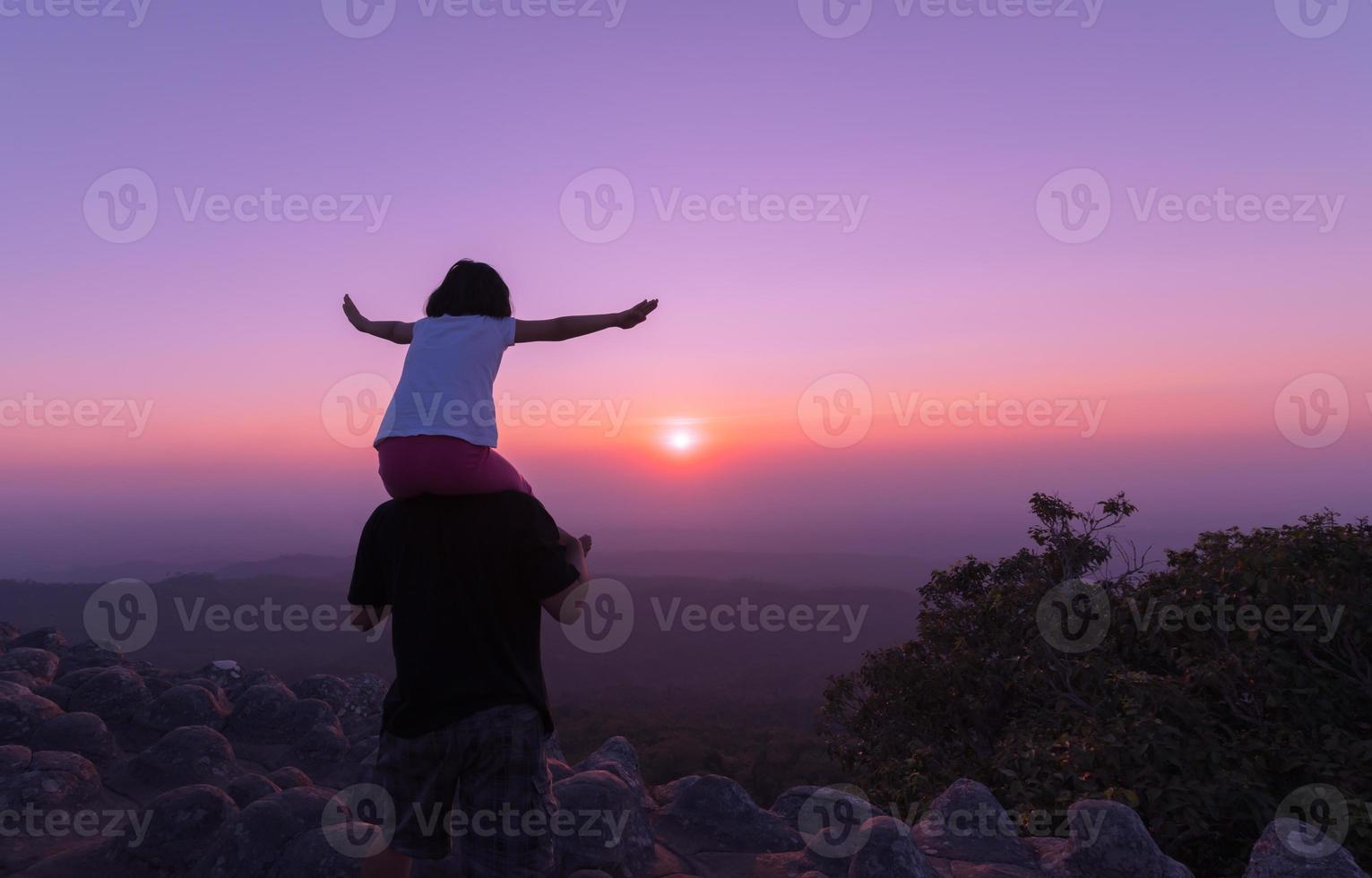 feliz pai e filha desfrutando em pôr do sol fundo, foto