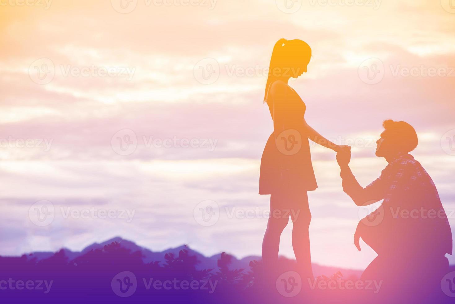 jovem casal dentro amor às pôr do sol em a montanha foto