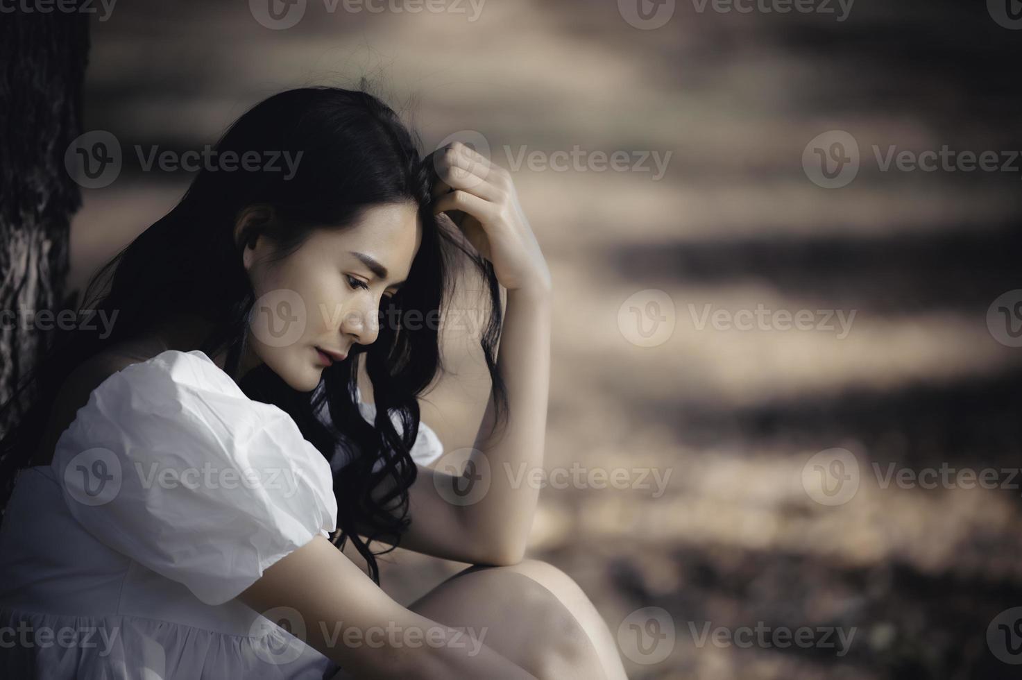 menina bonita asiática se sente sozinha na floresta, conceito de mulher triste, povo da tailândia, senhora tristeza sobre o amor do namorado, ela sentindo o coração partido foto
