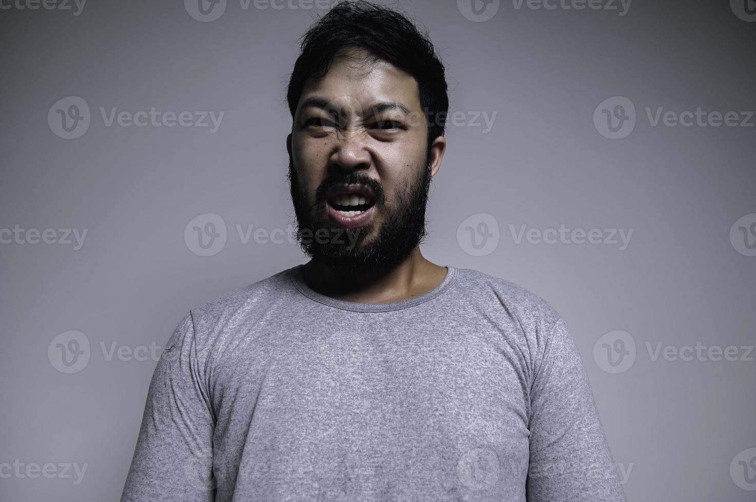 ásia bonito homem Bravo em branco plano de fundo, retrato do jovem estresse masculino conceito foto