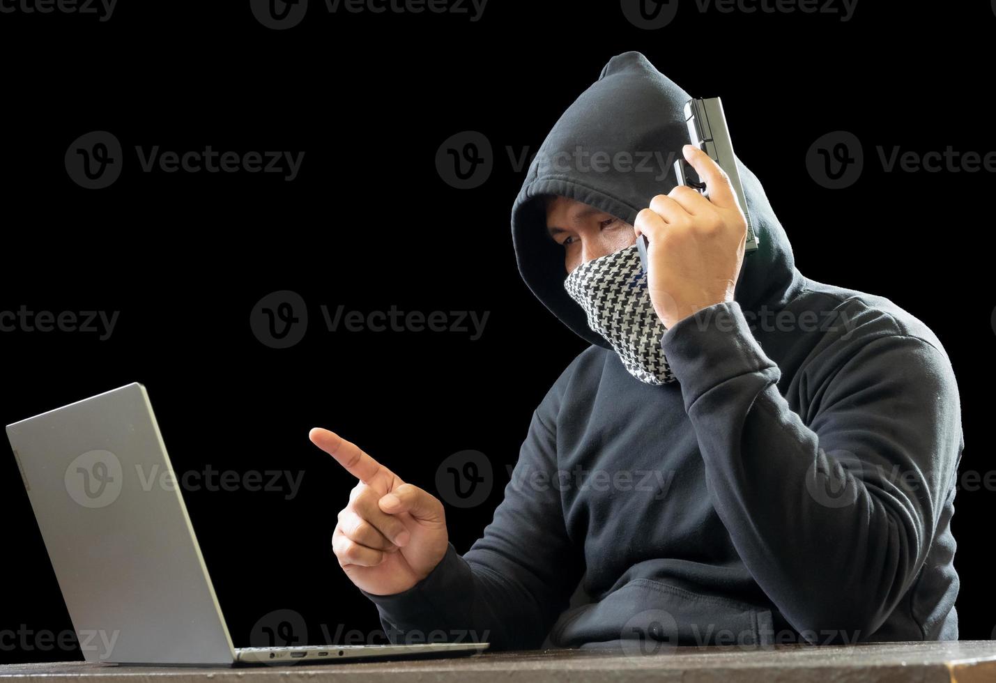 hacker espião homem uma pessoa com capuz preto sentado em uma mesa olhando computador laptop usado segurança de ataque de senha de login para circular dados digitais no sistema de rede da internet, fundo escuro noturno. foto