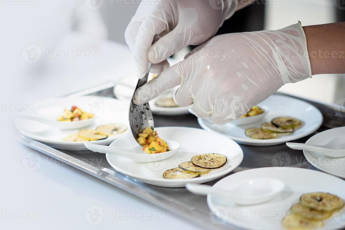 focado mão masculino chefe de cozinha dentro uniforme decorar comida, enfeites, preparar prato , dentro branco prato dentro cozinha. foto