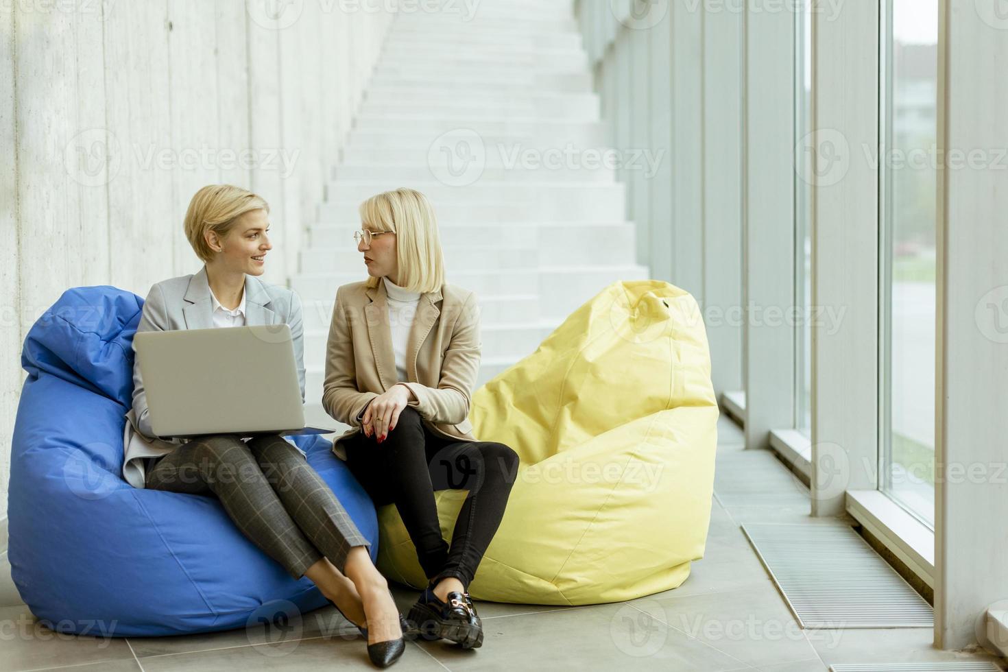 mulheres de negócios usando laptop em sacos preguiçosos no escritório moderno foto