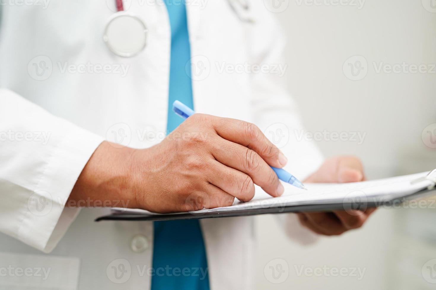 médico verificação e Nota diagnóstico remédio dentro prancheta do pacientes dentro hospital. foto