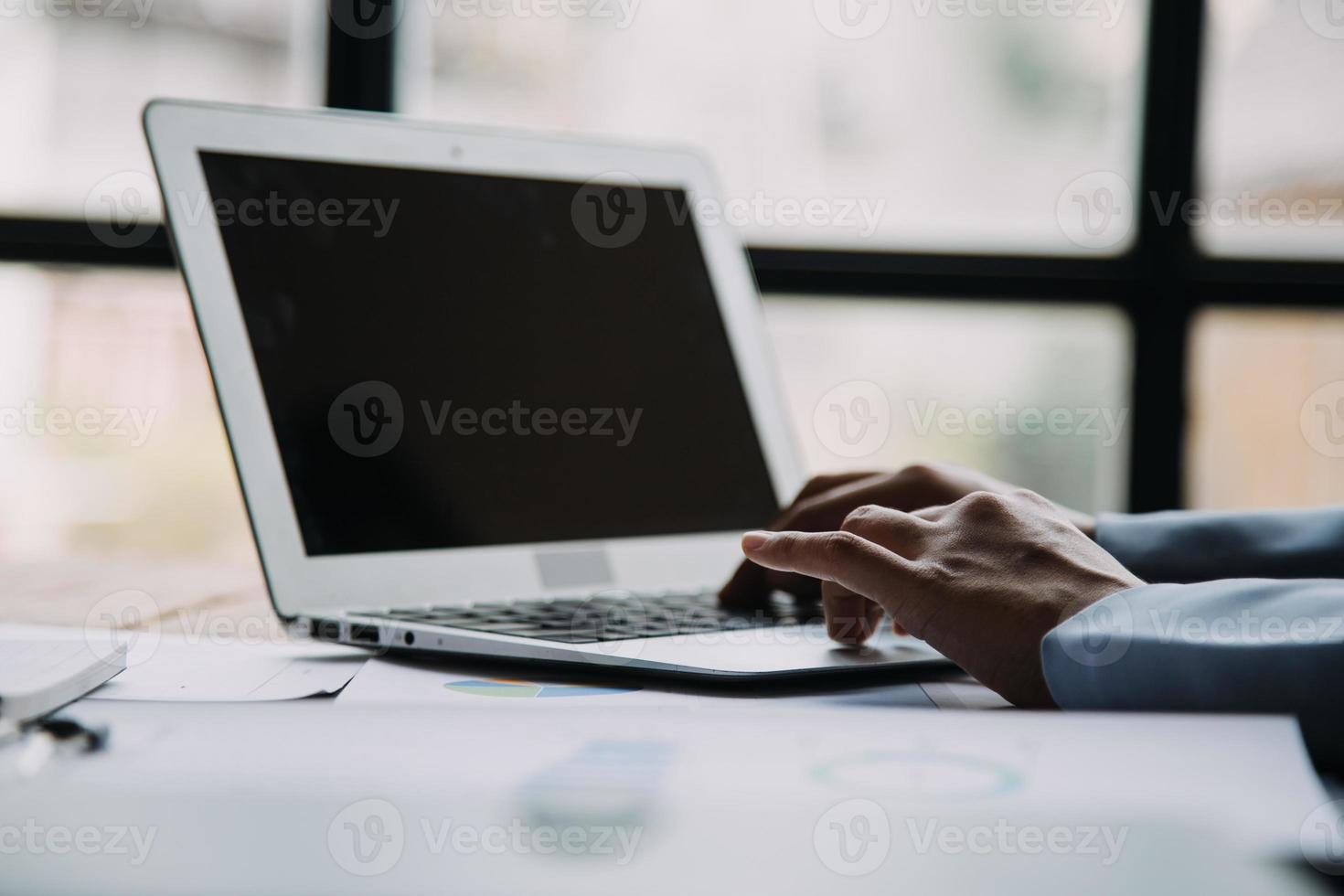 atraente sorridente jovem ásia o negócio mulher trabalhos às casa escritório, ásia mulher trabalhando em computador portátil computador segurando tábua. foto