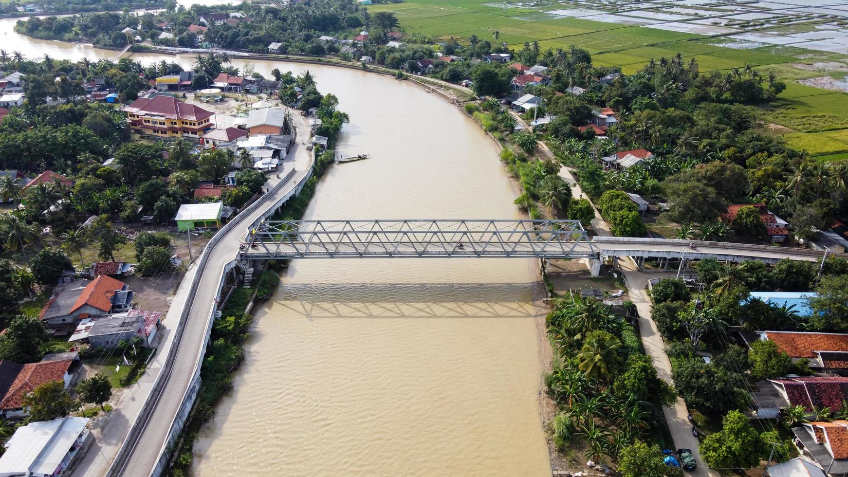 Bekasi, Indonésia 2021 - vista aérea de drone de uma longa ponte no final do rio conectando duas aldeias foto
