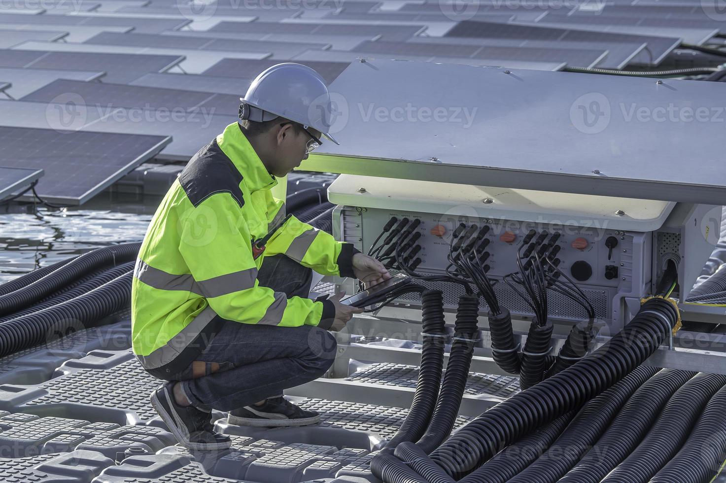 ásia engenheiro trabalhando às flutuando solar poder planta, renovável energia, técnico e investidor solar painéis verificação a painéis às solar energia instalação foto