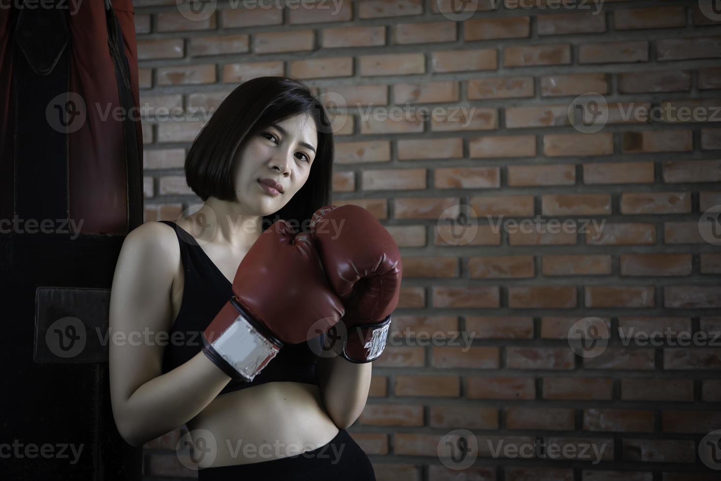 ásia lindo mulher vestem luva boxe dentro a Academia foto