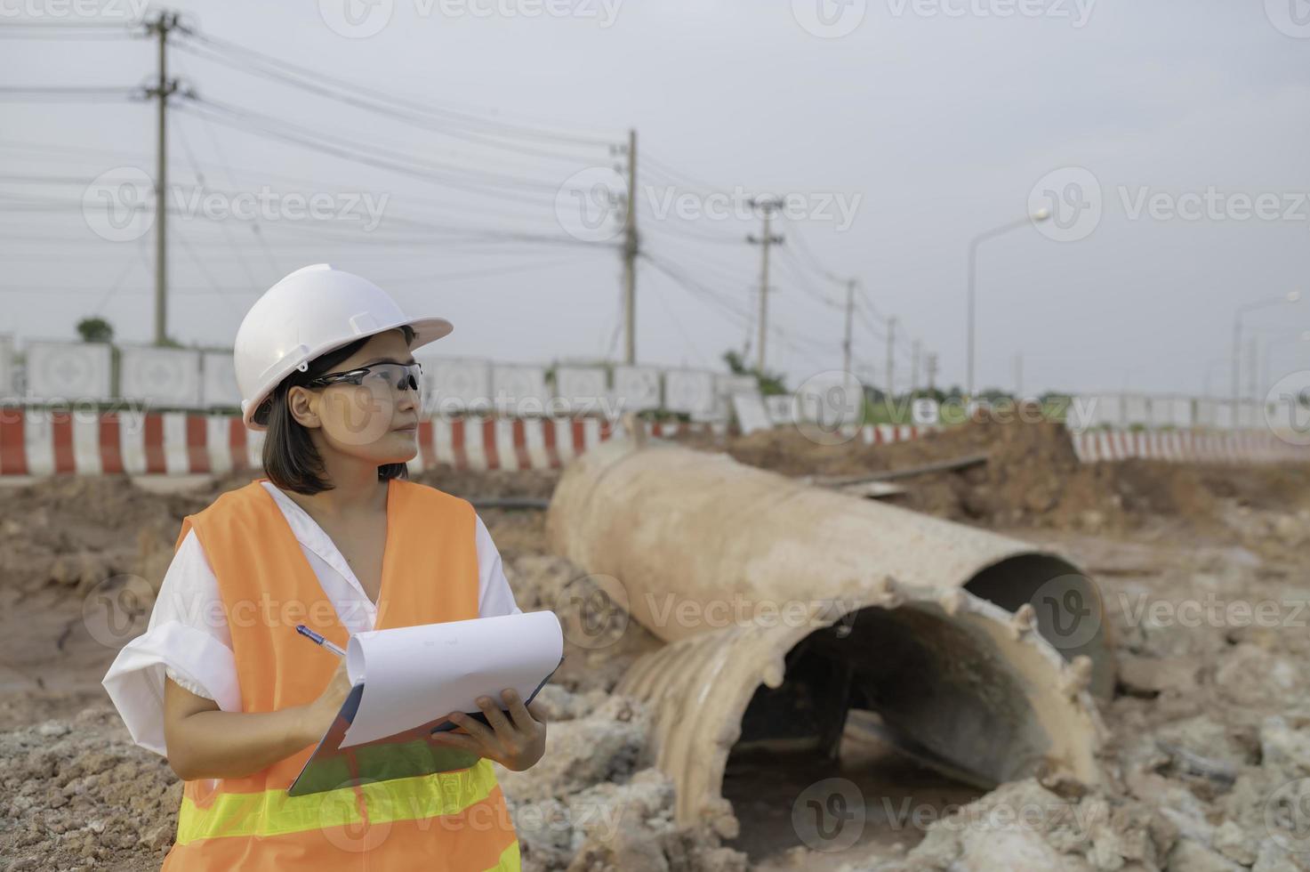 Civil engenheiros trabalhando às uma construção local, o companhia Gerente supervisiona a estrada construção. foto