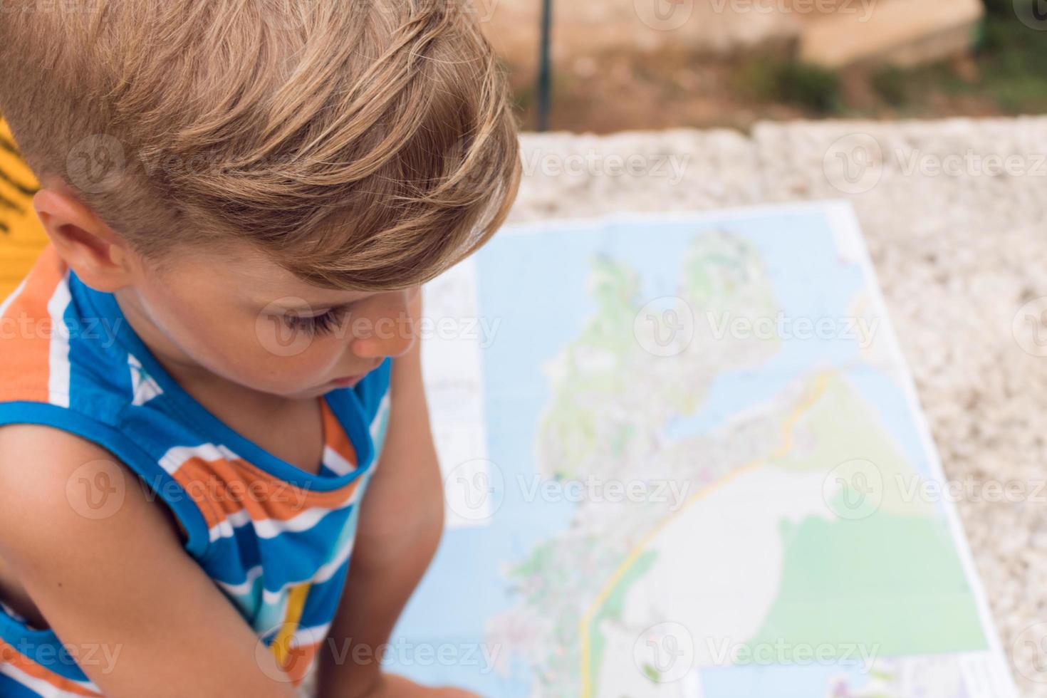 garotinho procurando orientação no mapa foto