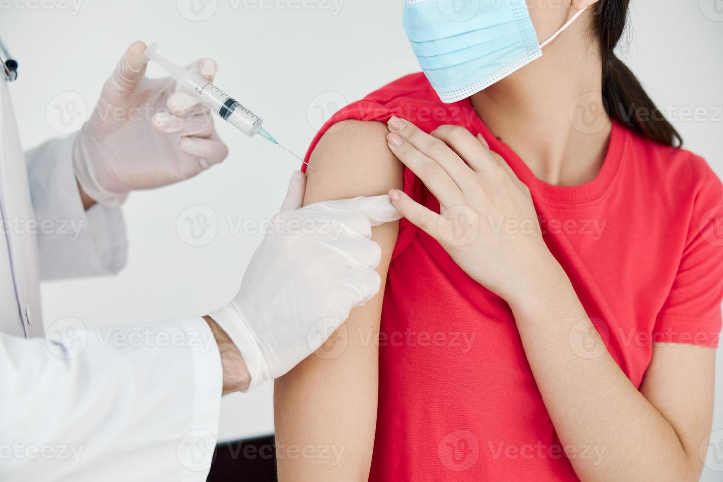 uma médico com uma seringa dentro dele mão faz a injeção dentro a ombro saúde cobiçado vacinação saúde Cuidado foto
