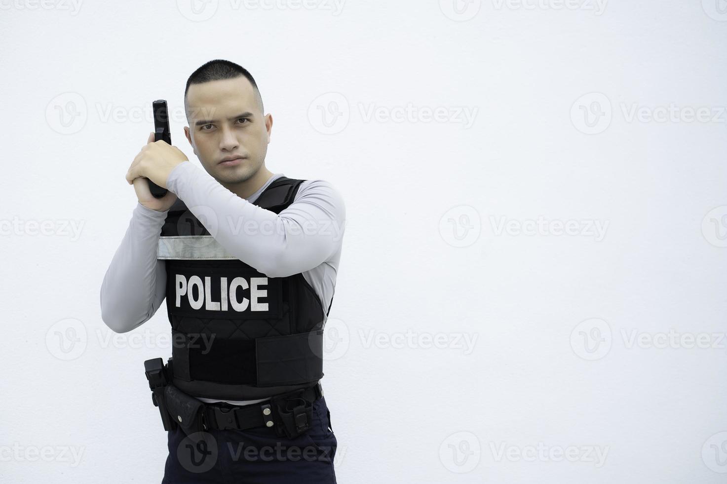 retrato do polícia aguarde arma de fogo dentro mão em branco plano de fundo, bonito ásia policial foto