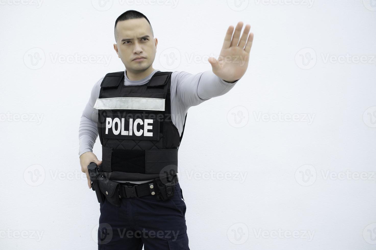 retrato do polícia aguarde arma de fogo dentro mão em branco plano de fundo, bonito ásia policial foto