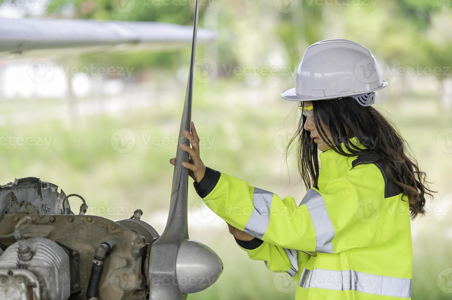 técnico consertando o motor do avião, engenharia aeroespacial feminina verificando motores de aeronaves, manutenção mecânica asiática inspeciona motor de avião foto