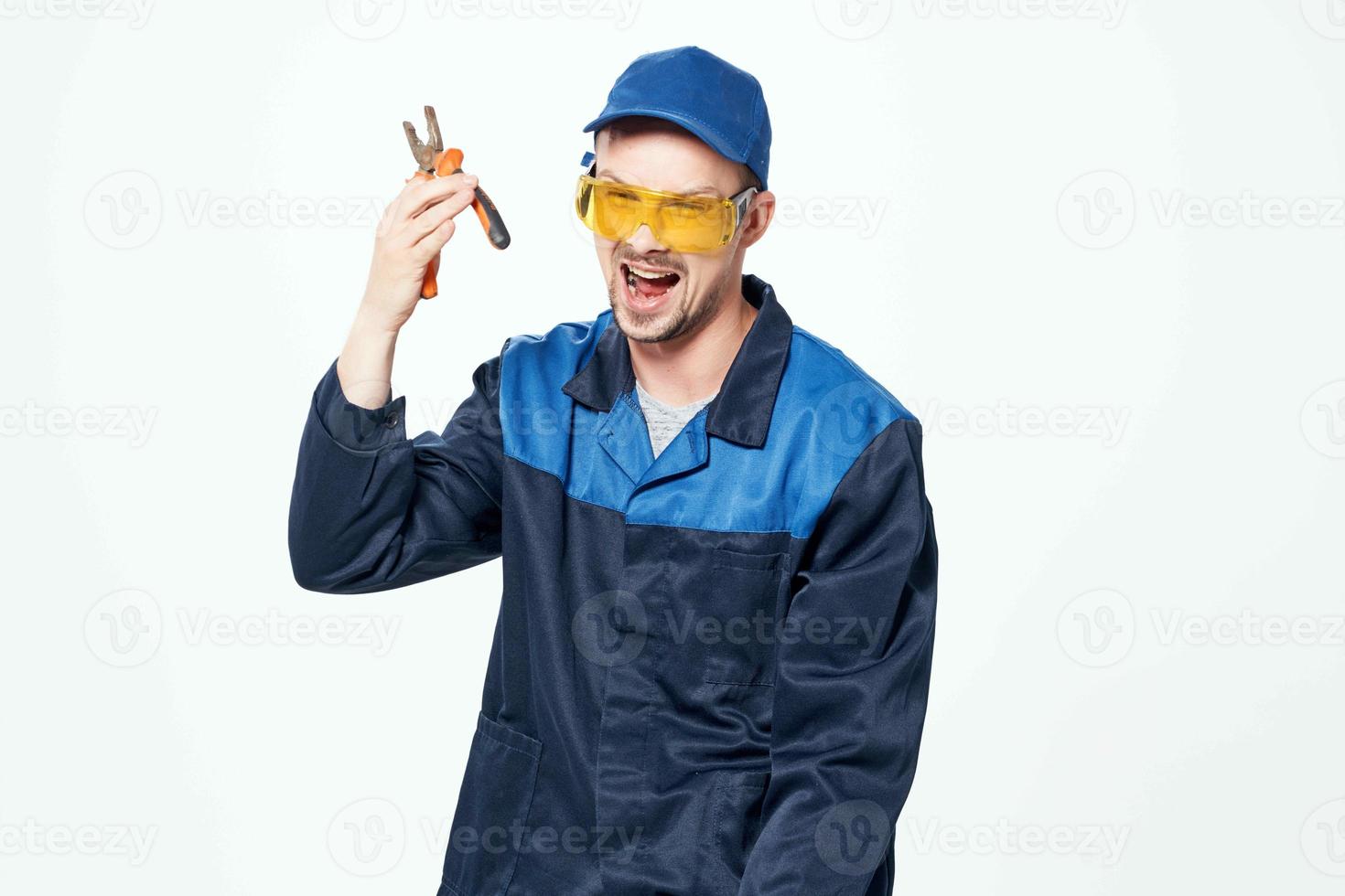 homem dentro construção uniforme com alicate dentro mãos reparar serviço foto