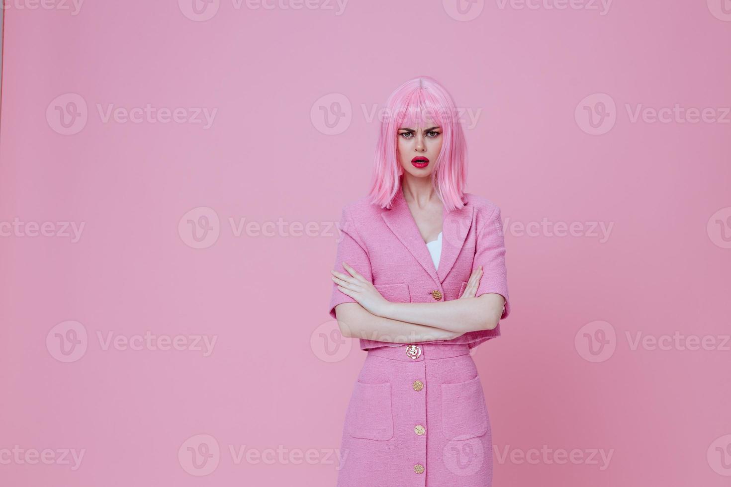 lindo elegante menina gestos com dele mãos com uma Rosa Jaqueta Rosa fundo inalterado foto